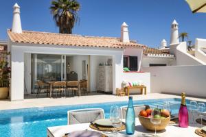 een villa met een zwembad en een villa met een eettafel bij Casa Girassol in Carvoeiro