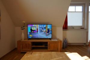 sala de estar con TV de pantalla plana en un soporte de madera en Meereskönig Wohnung 3, en Büsum