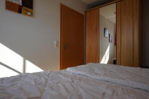 1 dormitorio con cama blanca y espejo en Meereskönig Wohnung 3, en Büsum