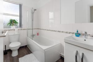 Baño blanco con aseo y lavamanos en Flatzy - Huge 7 Bed House Close to Football Stadiums en Liverpool
