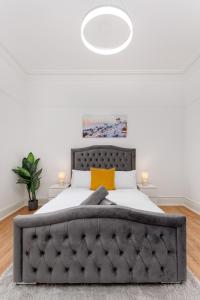 a bedroom with a large bed with a black tufted headboard at Flatzy - Huge 7 Bed House Close to Football Stadiums in Liverpool