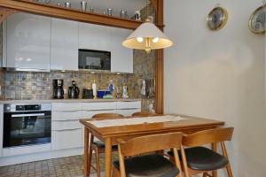 uma cozinha com uma mesa de madeira e algumas cadeiras em Schloss am Meer Wohnung 26 em Büsum