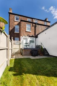 una casa con una valla y un patio en Flatzy - Huge 7 Bed House Close to Football Stadiums en Liverpool