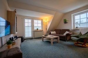 a living room with a couch and a table at Haus Kim Wohnung 2 in Büsum