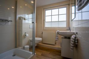 a bathroom with a sink and a toilet and a shower at Haus Kim Wohnung 2 in Büsum +17 photos