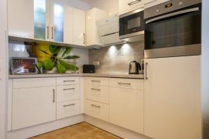 a white kitchen with white cabinets and appliances at Hohenzollernpassage Wohnung Seemöwe in Büsum