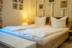 a bed with white sheets and pillows on it at Hohenzollernpassage Wohnung Seemöwe in Büsum