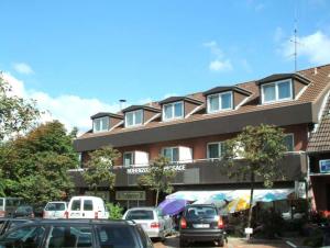 a building with cars parked in a parking lot at Hohenzollernpassage Wohnung Seemöwe in Büsum