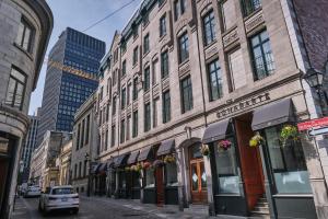 une rue dans une ville avec de grands bâtiments dans l'établissement Hotel Bonaparte, à Montréal