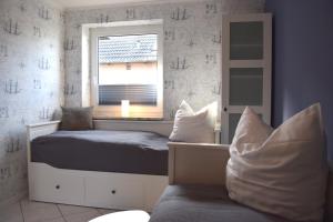 um pequeno quarto com uma cama e uma janela em Achtern Hafen em Büsum