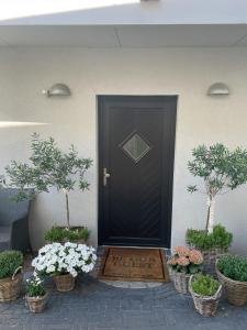 una porta nera con un tappetino di benvenuto davanti di Dat Strandhus Apartment 1 a Büsum