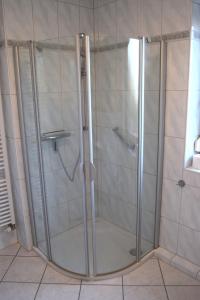 um chuveiro com uma porta de vidro na casa de banho em Achtern Hafen em Büsum
