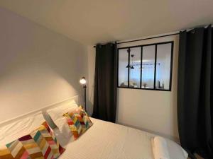 1 dormitorio con 1 cama y ventana en Designer - Centre Montereau en Montereau-faut-Yonne