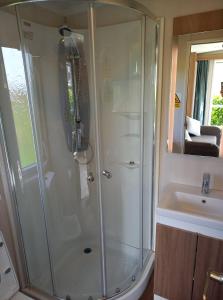 a bathroom with a shower and a sink at Luxury Pods at Mornest Caravan Park, Anglesey in Gaerwen