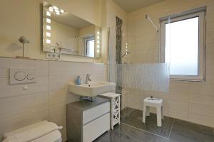 Un baño con lavabo, inodoro y espejo. en Meeresrauschen, en Büsum