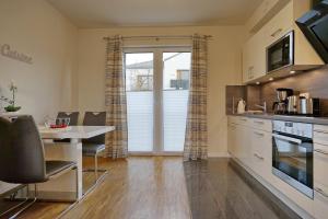 una cocina con una mesa y una mesa de comedor y una cocina con ventana en Meeresrauschen, en Büsum 3 fotos más
