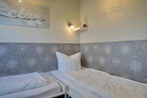 a room with two beds and a wall with at Deichstern in Büsum