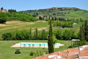 vistas a una piscina en un campo de césped en Agriturismo Marinello en Pienza