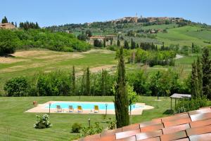 a view of a swimming pool in a grassy field at Agriturismo Marinello in Pienza