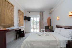 a bedroom with a bed and a desk and window at Naias in Neos Marmaras