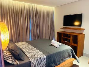 a hotel room with a bed and a flat screen tv at Bali BG Casa Bamboo in Barra Grande