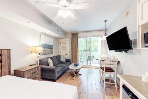 uma sala de estar com um sofá e uma televisão em Baytowne Wharf - Pilot House #323 em Destin