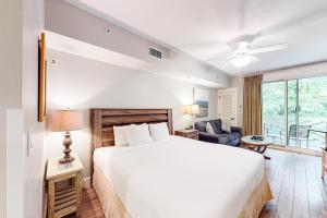 a bedroom with a large bed and a living room at Baytowne Wharf - Pilot House #323 in Destin +19 photos