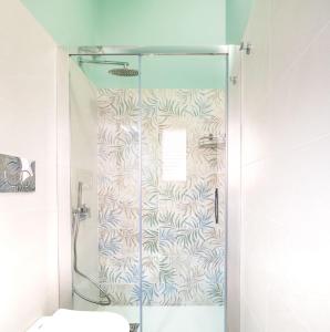 La salle de bains est pourvue d'une douche avec une porte en verre. dans l'établissement A casa tua Affitti brevi, à Noto