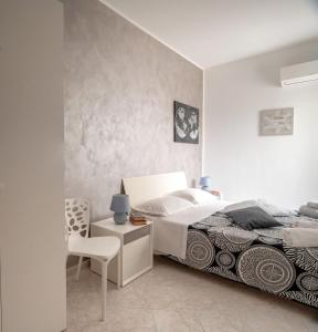 ein Schlafzimmer mit einem Bett und einem Stuhl in der Unterkunft A casa tua Affitti brevi in Noto