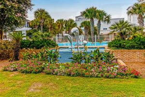 a fountain with swans in a park with flowers at Baytowne Wharf - Pilot House #323 in Destin