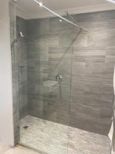 a shower with a glass door in a bathroom at Contemporary & Spacious Courtyard Unit in Gillitts