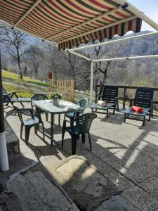 een patio met een tafel en stoelen onder een paviljoen bij Chalet Tessa BELLAGIO in Bellagio
