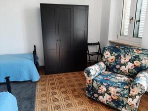 ein Wohnzimmer mit einem Sofa und einem Stuhl in der Unterkunft CASA FRIDA in Canelli