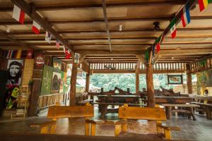 a room with wooden tables and benches and flags at Indra Valley Inn Bukit Lawang in Bukit Lawang