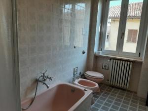 ein Badezimmer mit einer rosa Badewanne und einem WC in der Unterkunft CASA FRIDA in Canelli