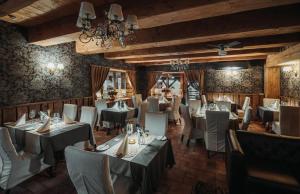 een restaurant met tafels en stoelen en een kroonluchter bij Agate Hotel in Ozolnieki