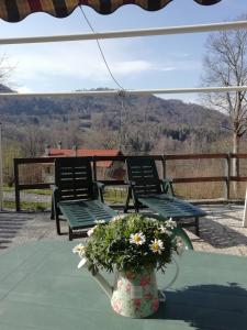 two chairs and a table with a vase of flowers at Chalet Tessa BELLAGIO in Bellagio