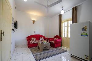 a living room with a red couch and a table at Noby Guest House in Luxor