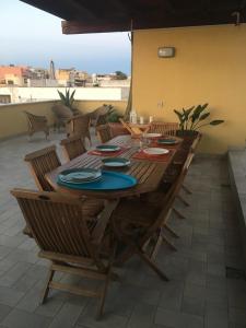 a wooden table and chairs on a patio at Attico sul Porto Vecchio - Lampedusa in Lampedusa