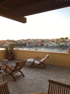 a balcony with chairs and a view of a city at Attico sul Porto Vecchio - Lampedusa in Lampedusa