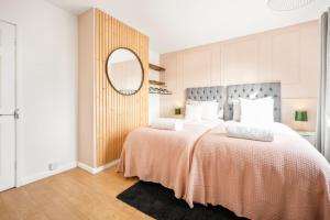1 Schlafzimmer mit 2 Betten und einem Spiegel in der Unterkunft Stylish & Convenient 4BR House w/ Garden & Parking in Bournemouth
