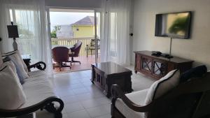a living room with a couch and a table and a television at Sea Palms Beach Holiday in St Mary