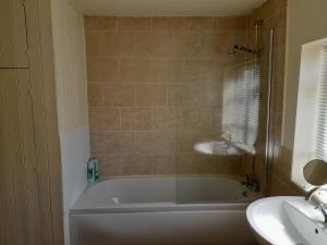 a bathroom with a bath tub and a sink at The Little House Louth in Louth