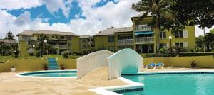 una piscina del complejo con un tobogán frente a un edificio en Sea Palms Beach Holiday, en Saint Mary