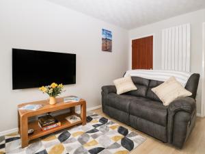 a living room with a couch and a tv at Lodmoor House in Weymouth