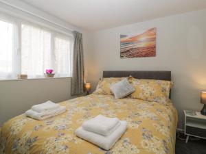 a bedroom with a yellow bed with towels on it at Lodmoor House in Weymouth