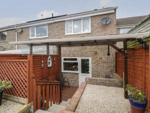 a detached house with a wooden pergola at Lodmoor House in Weymouth