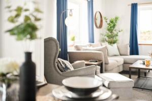ein Wohnzimmer mit einem Sofa und einem Stuhl in der Unterkunft Stylish & Convenient 4BR House w/ Garden & Parking in Bournemouth