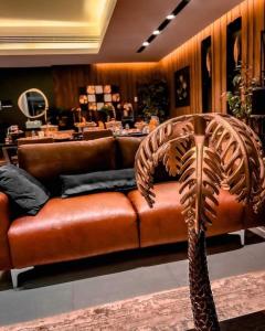 a brown leather couch sitting in a room at G R A N D C H A L E T in Salalah
