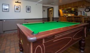 a pool table in a bar with a green at Redesdale Arms in Otterburn